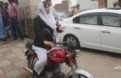 އަންހެން ކެންޑިޑޭޓް ސައިކަލްގައި ދޮރުން ދޮރަށް ކެމްޕޭން ކުރުމުގައި